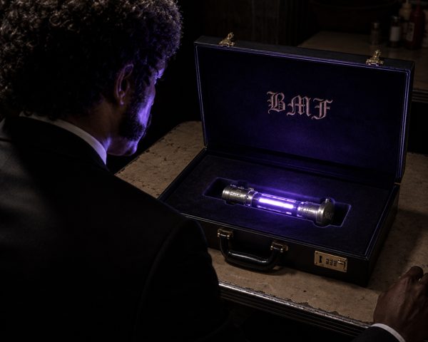 A man opening a briefcase that glows with a purple light